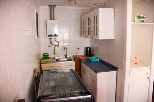 a small kitchen with a sink and a stove at Habitaciones Barrancas en San Antonio - Cabañas y Mini Departamentos in San Antonio