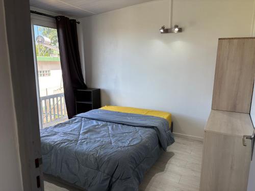 a small bedroom with a bed and a window at Coin de paradis in Le Tampon