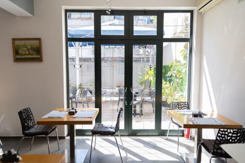 una habitación con mesas y sillas y una ventana grande en Hotel Liqeni, en Tirana