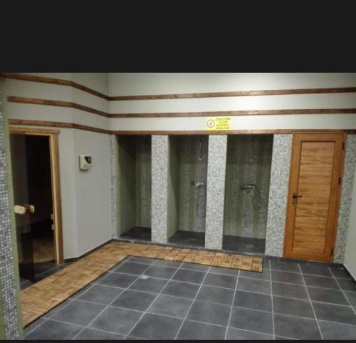 a empty room with two doors and a tile floor at Aspen Luxury Apartamnet in Razlog