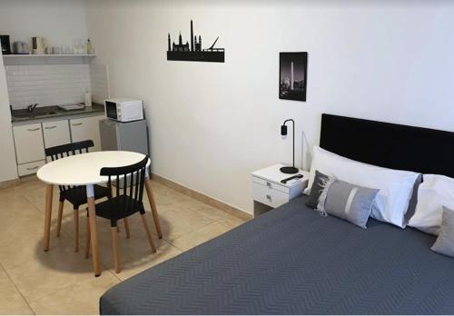 a bedroom with a bed and a table and a kitchen at Appart Tucuman in Buenos Aires