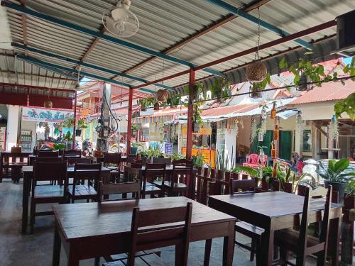 an empty restaurant with wooden tables and chairs at Ning Ning hostel Dondet in Don Det