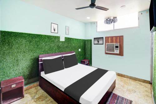 een slaapkamer met een bed en groene muren bij Super Hotel O CITY HEIGHTS in Dhanbad
