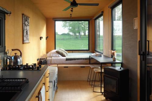 a small room with a bed on a window at Parcel Tiny House I L'Arche des Hays in Les Hays