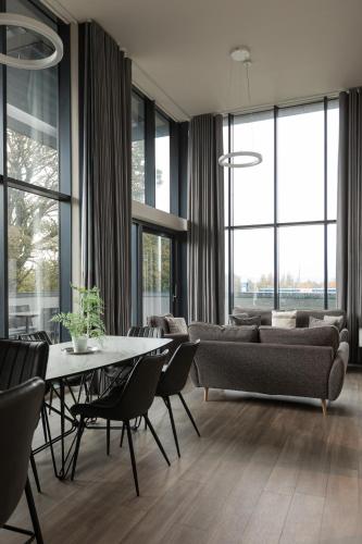 a living room with a couch and a table with chairs at Skyline Serenity Ultra Luxury apartments by Luxus in Belfast
