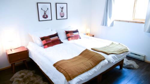 Un dormitorio con una gran cama blanca con almohadas rojas. en Lay Back Lodge, en Kimberley