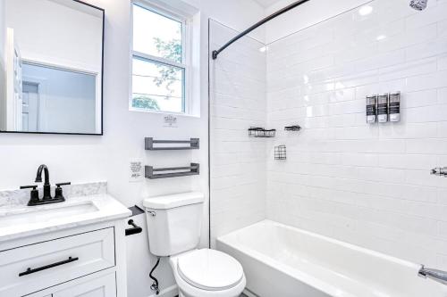a white bathroom with a tub and a toilet and a sink at Newly Built Lake House Near NYC EWR MetLife AD Mall in Passaic