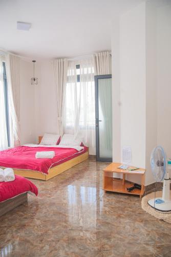 a bedroom with two beds and a fan at Vanille De House in Xuan An
