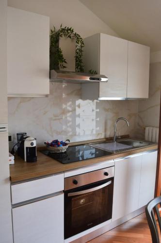 a kitchen with white cabinets and a sink at Gioia's House in Montesilvano
