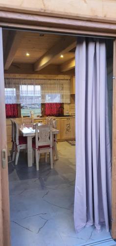 a dining room with a table and a curtain at Bachledowy Wierch 2 in Czerwienne