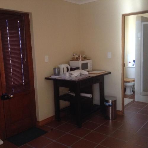 a kitchen with a table with a microwave on it at LAVENDERS COTTAGE in Prince Albert