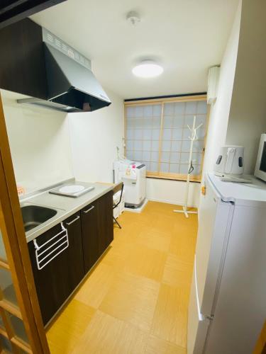 a small kitchen with a sink and a refrigerator at TAKEITEI Japanese-style lodge in Kyoto