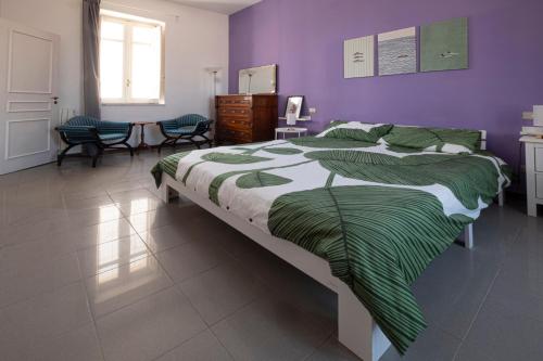 a bedroom with a large bed and purple walls at san Lorenzo by the sea in Augusta