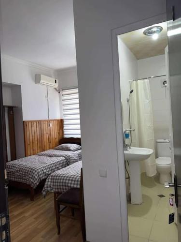 a room with two beds and a sink and a bathroom at hotel floreale in Rustavi