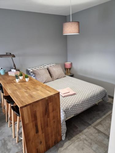a bedroom with a bed and a wooden table at Le Cocon de Pinerato in Albi