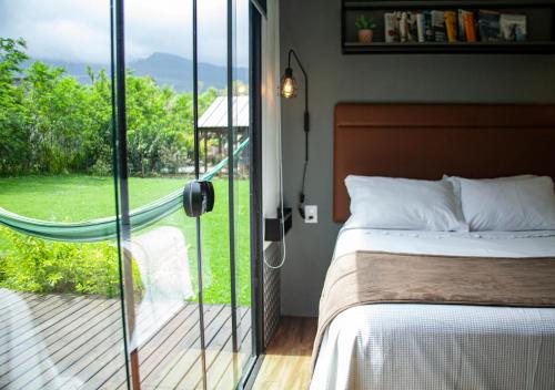 a bedroom with a bed and a sliding glass door at Éden Bed & Nature in Praia Grande