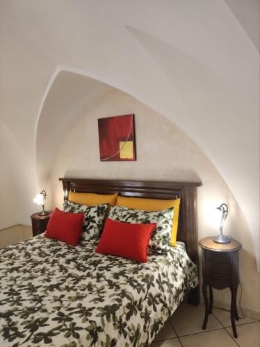 a bedroom with a bed with two red pillows at Casa vacanza Gallipoli centro in Gallipoli