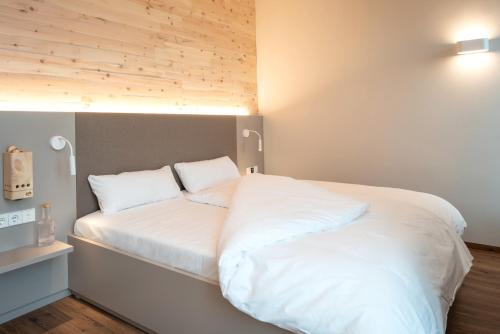 a bed with white sheets and pillows in a room at RELAXANS Hotel in Dinkelsbühl
