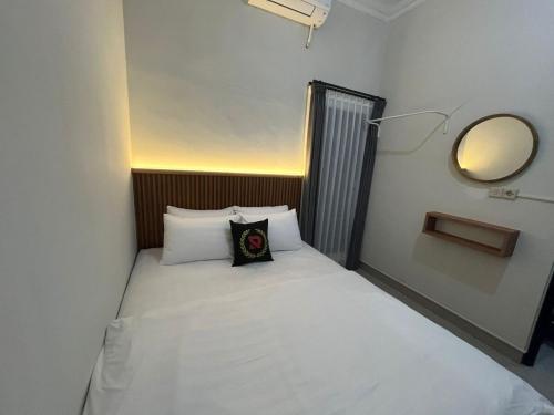 Cama pequeña en habitación pequeña con espejo en Villa 160 Prambanan, en Randugunting