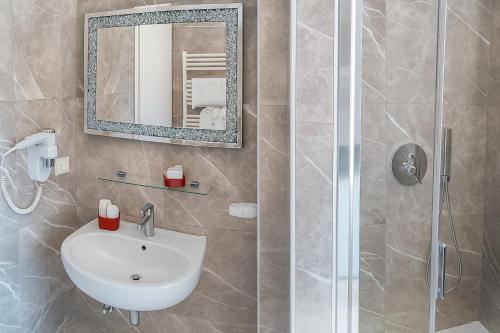 a bathroom with a sink and a shower with a mirror at Bed Cinecitta’ in Rome