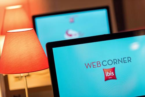 a computer screen with a web corner sign next to a lamp at ibis Marseille Centre Gare Saint Charles in Marseille