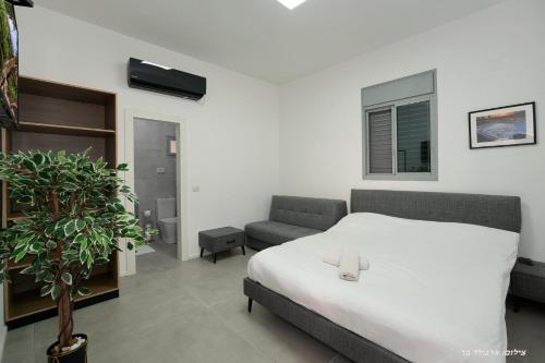 - une chambre avec un lit, une chaise et une plante dans l'établissement וילות היוקרה עידן הנוף ואחוזת אסתובן, à Ya‘ara