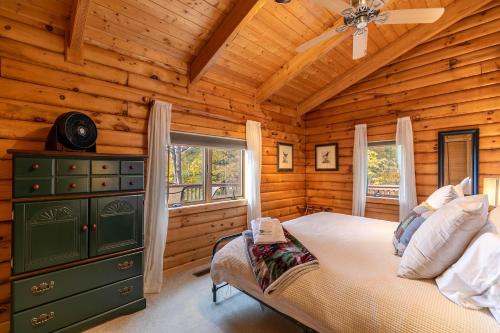Un dormitorio con una cama en una cabaña de troncos en Angels Envy, en Blowing Rock