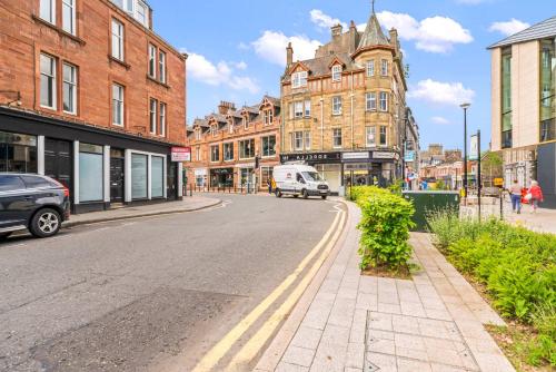 ガラシールズにあるStylish 4 Bed-Town Centreの建物が立ち並ぶ街路と、その通りを走るバン