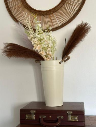 a white bucket with feathers on top of a suitcase at The Manor by Orchids in Arusha