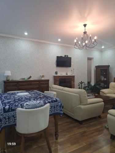 a living room with a couch and a table and chairs at Tsitadel in Zugdidi