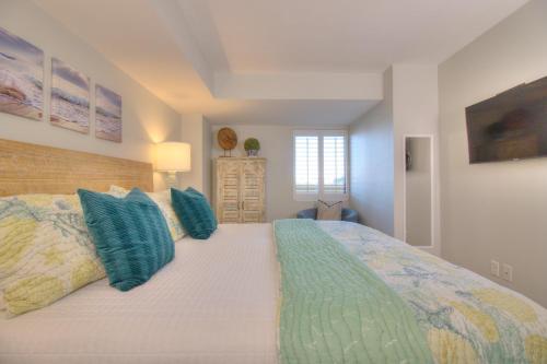 a bedroom with a large bed with blue pillows at Verandas - 303 in Myrtle Beach