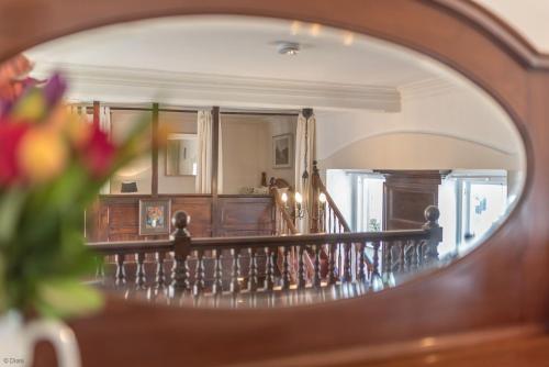 un miroir reflétant un escalier dans le salon dans l'établissement Capel-Bach, à Llanystumdwy