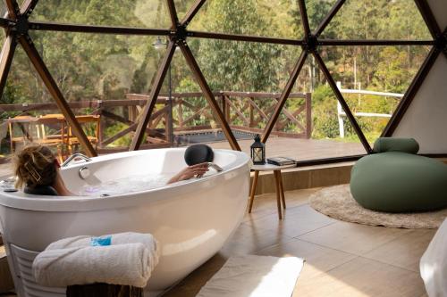 a child in a bath tub in a room with a window at Skydomo in Salesópolis