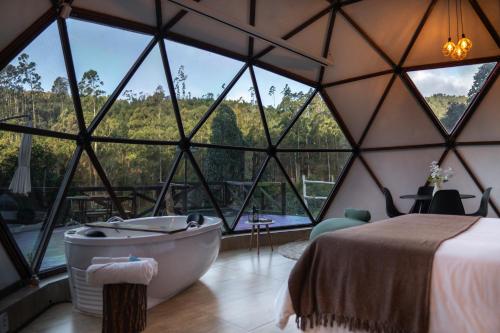 a room with a tub and large windows at Skydomo in Salesópolis