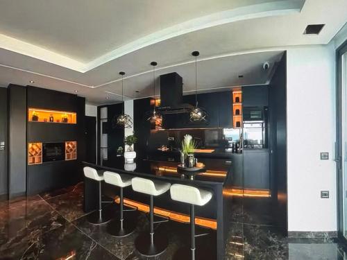 une cuisine aux murs noirs et un bar avec tabourets dans l'établissement Corfu serenity Relax & Stay, à Afionas