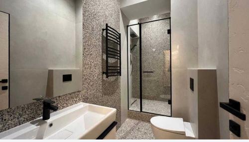 a bathroom with a white sink and a toilet at Rynok Square Pidzemelya in Lviv