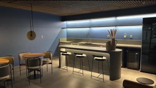 a kitchen with a bar with stools and a sink at Setai, Aquamaris- pé na areia in João Pessoa