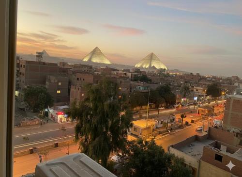 a view of a city with pyramids in the background at Boutique De Pirámides Nómadas in Cairo