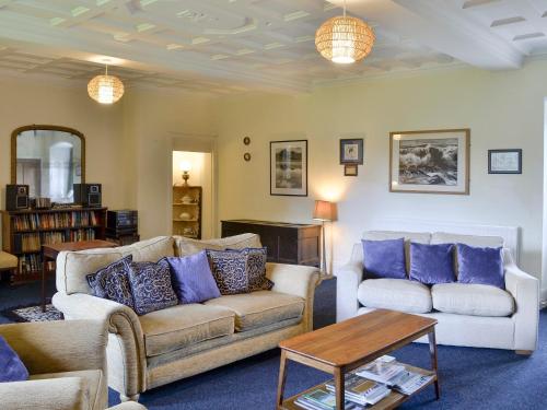 a living room with two couches and a table at Whitehall Pele Tower in Mealsgate