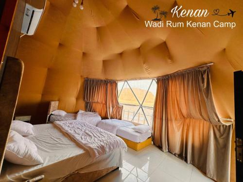 ein Schlafzimmer mit zwei Betten und einem großen Fenster in der Unterkunft Wadi Rum Kenan Camp in Wadi Rum