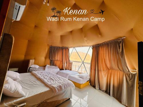 a bedroom with two beds and a window at Wadi Rum Kenan Camp in Wadi Rum