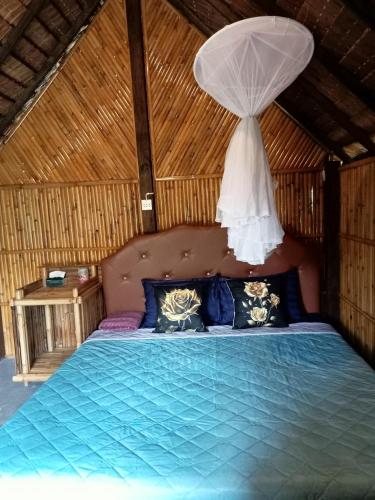 a bedroom with a blue bed with a white canopy at koh mook oyoy reggaebar bungalow in Ko Mook