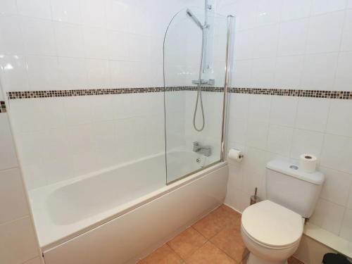 a white bathroom with a shower and a toilet at Pears Suite - 1 Bedroom - Sleeps 2 in Whitehaven
