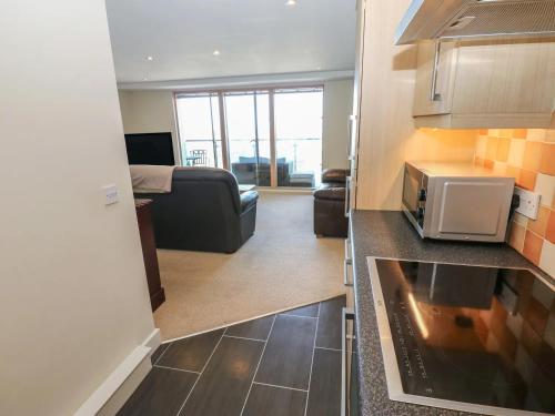 a kitchen and living room with a couch and a microwave at Pears Suite - 1 Bedroom - Sleeps 2 in Whitehaven