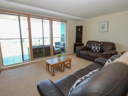 a living room with a leather couch and a table at Pears Suite - 1 Bedroom - Sleeps 2 in Whitehaven