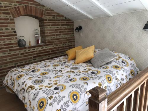a bedroom with a bed with a comforter on it at Gîte atypique La Bastilac in Garganvillar