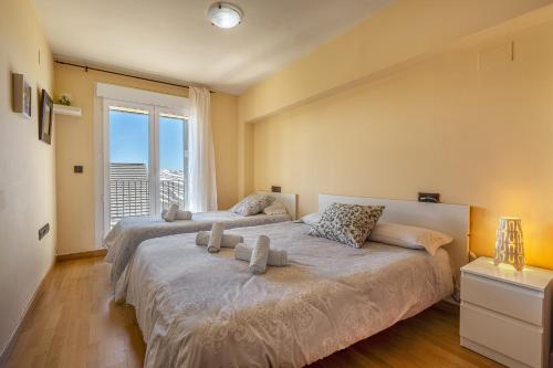 a bedroom with two beds and a large window at Alpine Sierra Nevada in Sierra Nevada