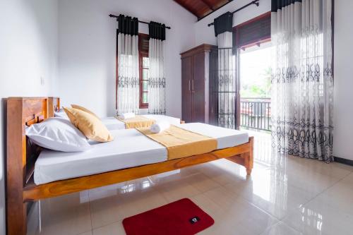 a bed in a room with a large window at Villa Amora in Patuwata