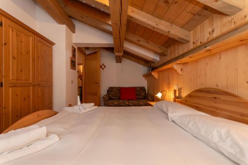 a large white bed in a room with wooden walls at Dreamful Cottage in Selva di Cadore