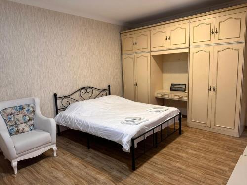 un dormitorio con una cama y una silla en Tbilisi historical center, en Tiflis